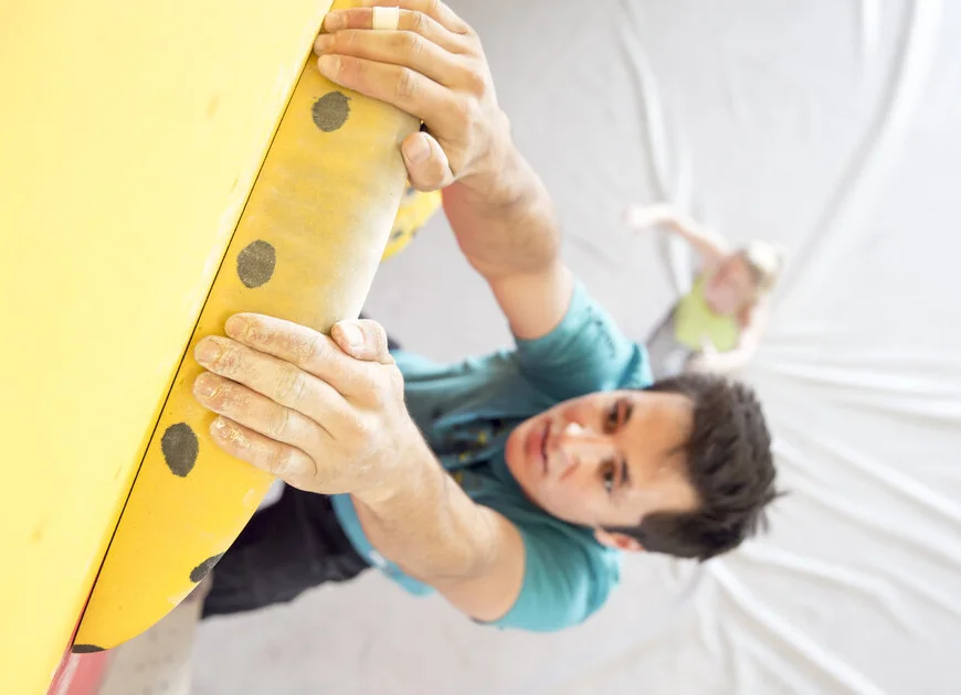 Ein Mann beim Training am Campusboard. | © DAV/ Hansi Heckmair Ein Mann beim Training an einem gelben Campusboard - aus der Vogelperspektive fotografiert | © DAV/ Hansi Heckmair